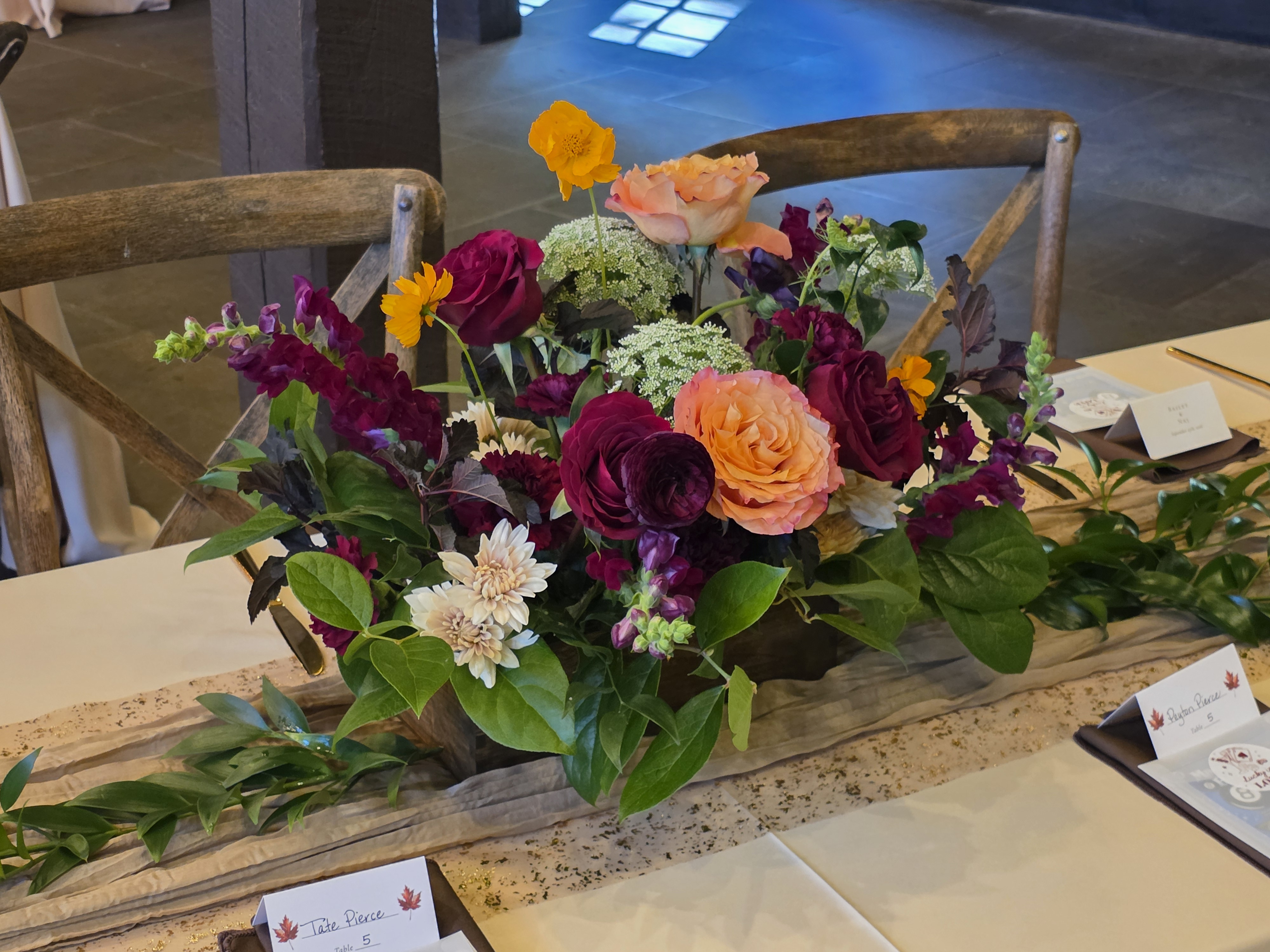 Burgundy and peach flowers arranged for a wedding reception