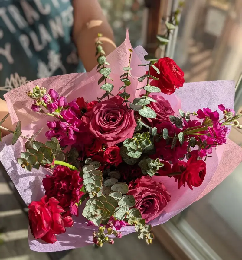 Red and pink roses with eucalyptus wrapped in pink paper